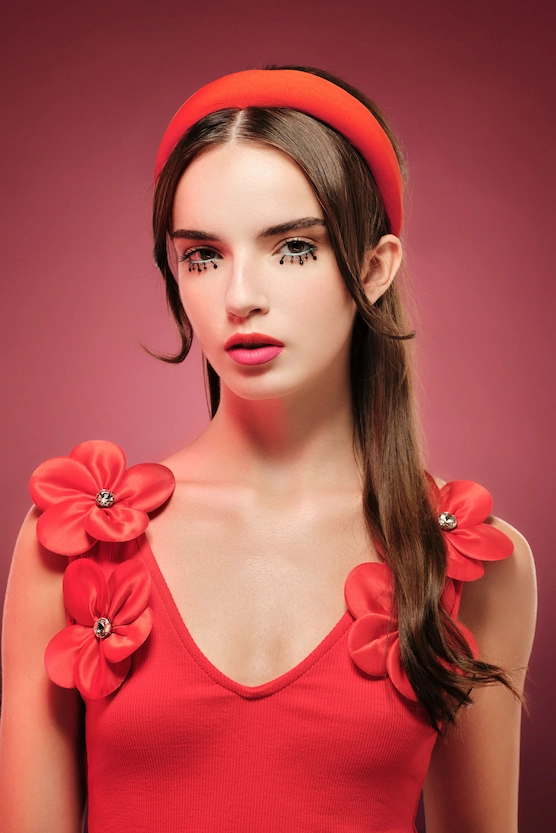 Doll-like eyes with drawn-on lashes, graphic eyeliner, and pop lips.